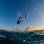 A person surfing and flying a parachute at the same time in Kitesurfing. Bonaire, Caribbean